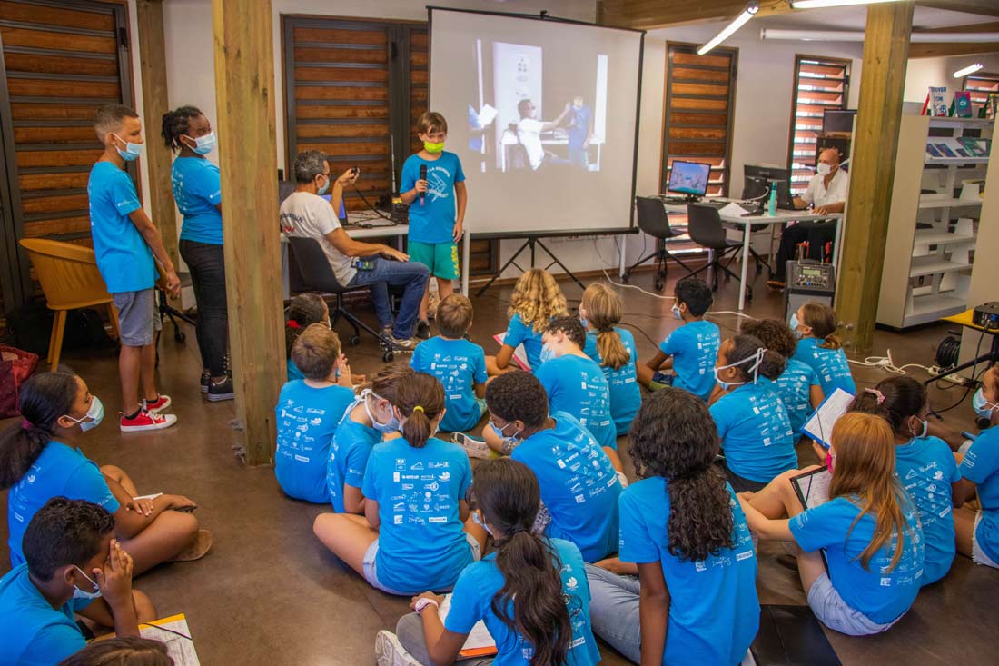 Enfants d’une classe qui font une présentation devant un écran