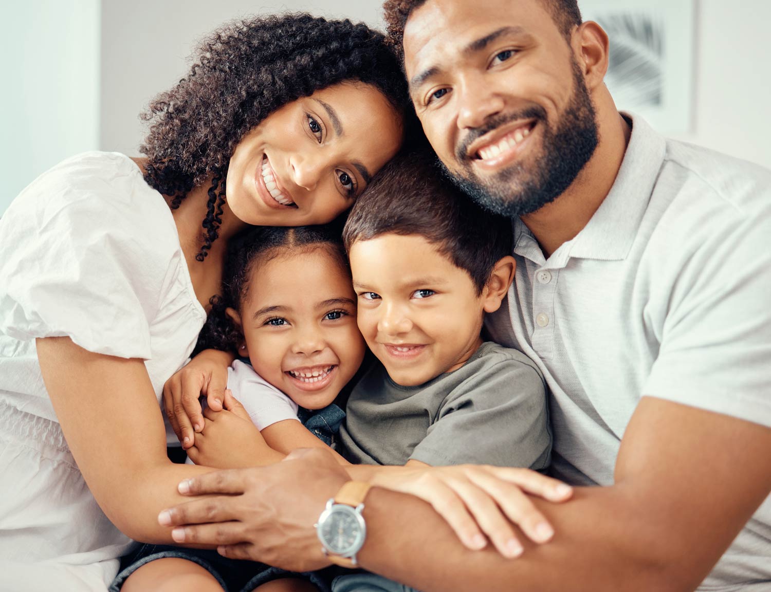 Une famille avec 2 parents et 2 enfants dans les bras